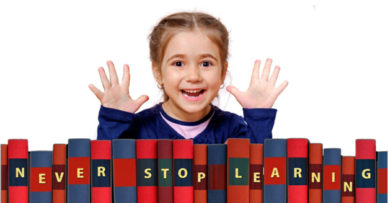Girl beaming in front of books saying 'Never Stop Learning'